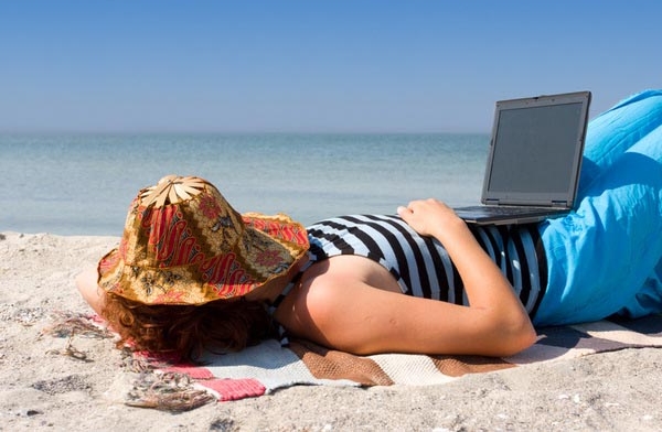 Girl sleep with laptop computer at sea beach